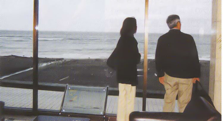 ロビーの窓から海を見る夫婦