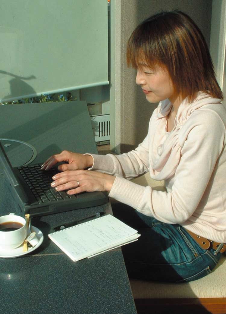 ノートパソコンを使ってDTPを行っている女性編集者