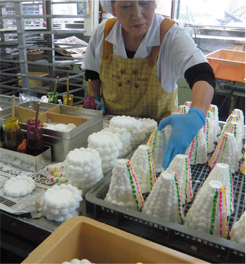 吉田食品工場で落雁に色づけをしている女性