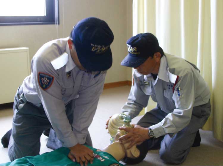 心臓マッサージ、手動式人工呼吸器を口に当ててる救急救命士たち