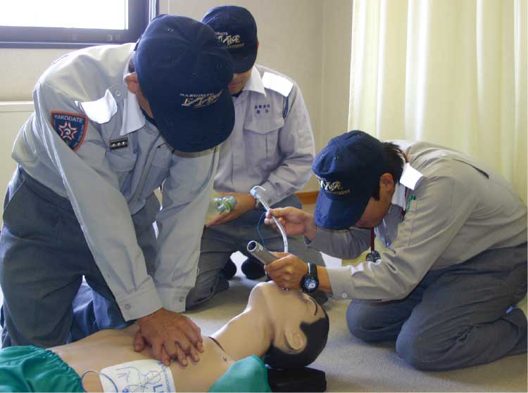 心臓マッサージ、口の中を確認している救急救命士たち